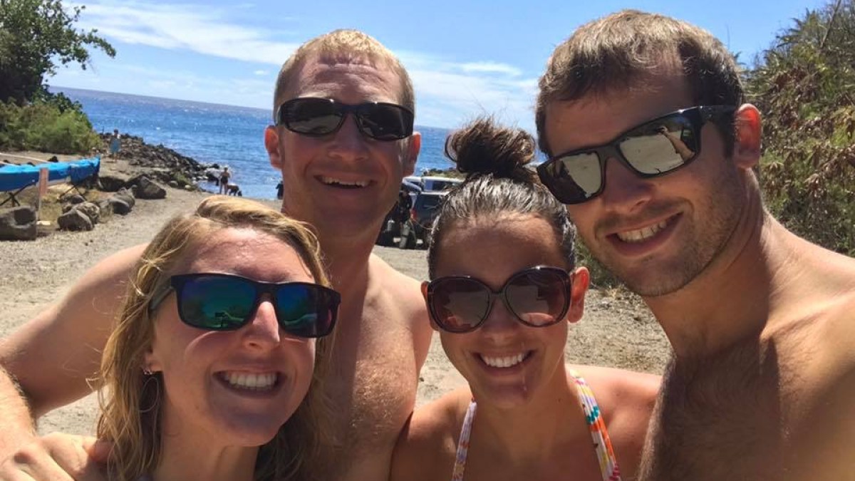 a couple of people that are standing in the sand on a sunny day
