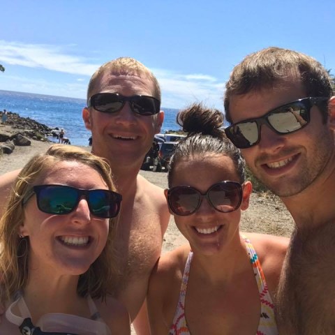 a couple of people that are standing in the sand on a sunny day