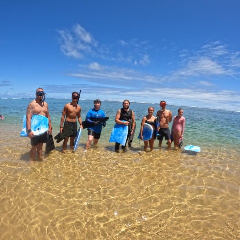 a group of people standing on top of a sandy beach